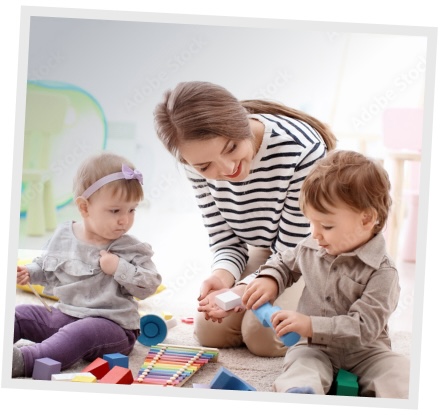 Nounou qui s'occupe de deux enfants dans une salle de jeux