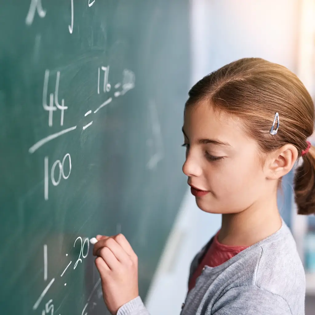 Une jeune élève apprend les mathématiques sur un tableau lors d’un cours particulier à la maison à Bousse