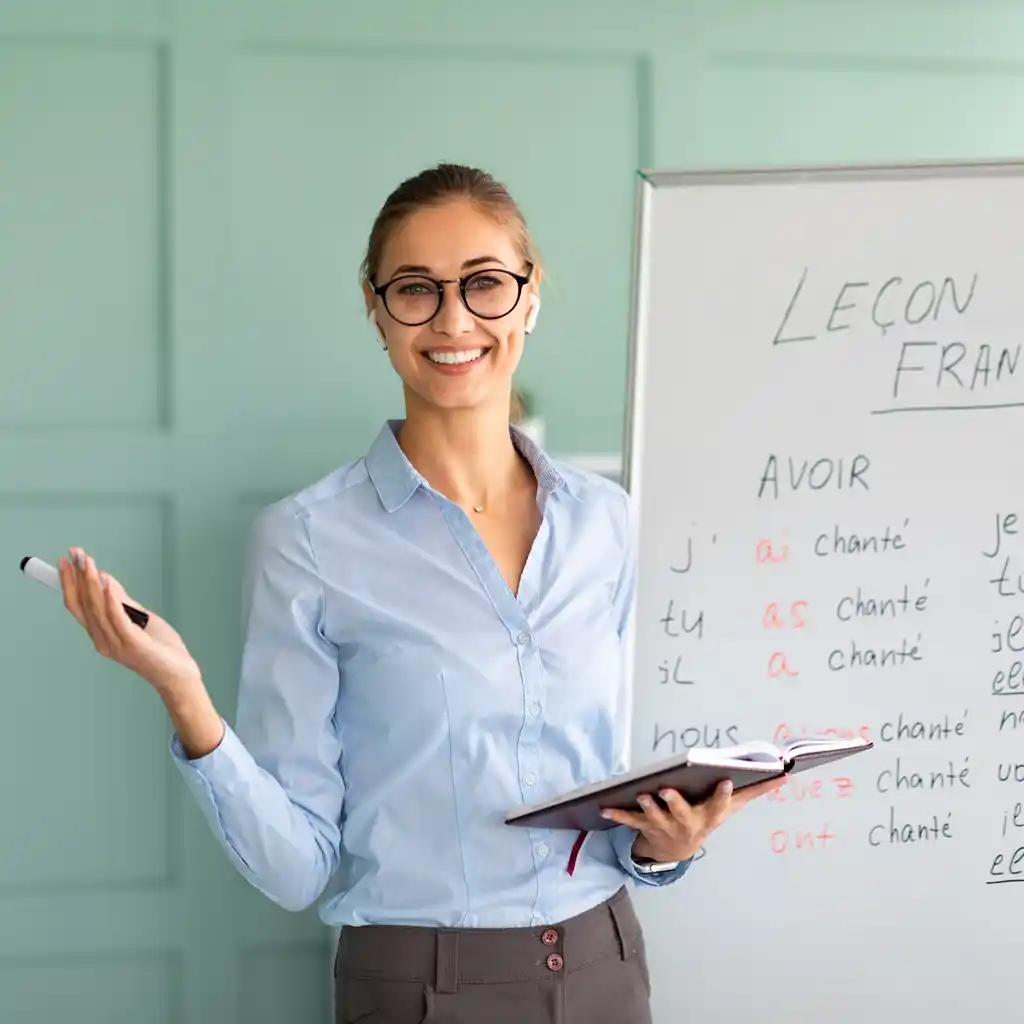 Enseignante de français Scol'Avenir devant un tableau blanc expliquant des conjugaisons à Bousse