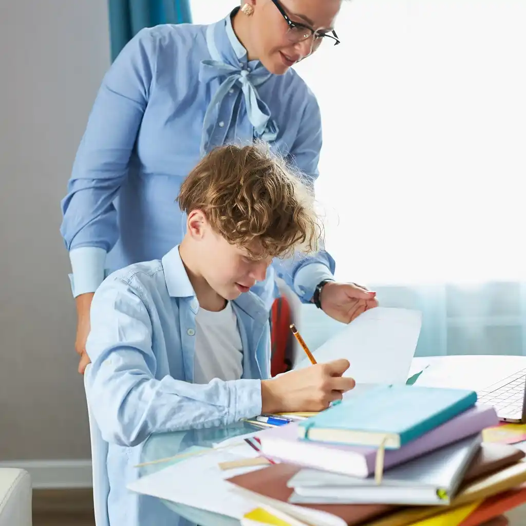 Une professeure d’anglais accompagne un élève à domicile pendant un cours particulier à Talange