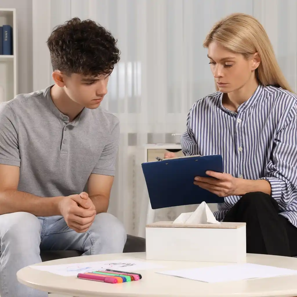 Un adolescent suit un cours de soutien scolaire à domicile sur une tablette avec sa professeure à Fameck