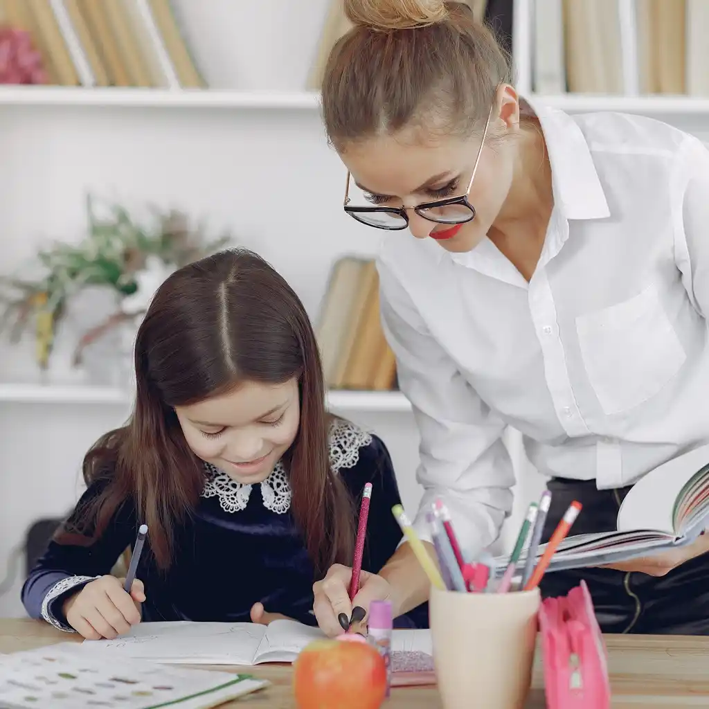 Une professeure donne un cours de soutien scolaire à domicile à une élève de primaire à Hettange