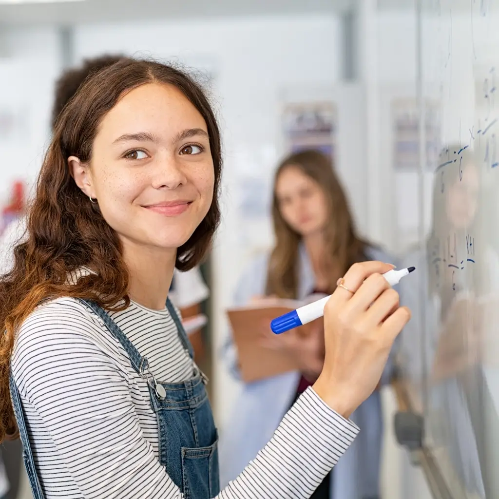 Une lycéenne fait des exercices de mathématiques sur un tableau pendant un cours de soutien scolaire à Florange