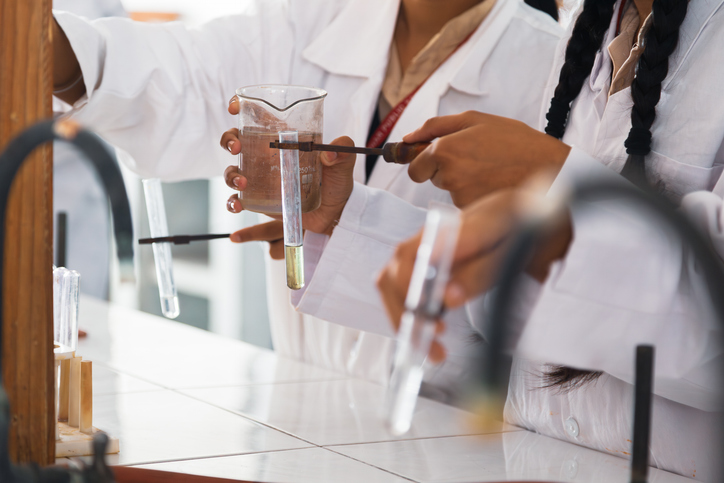 Elèves de terminales en cours de chimie participant à un atelier pratique avec des tubes à essai
