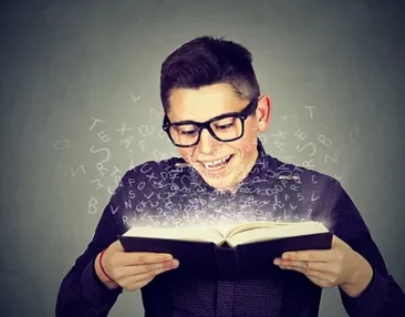 Garçon souriant en train de lire un livre