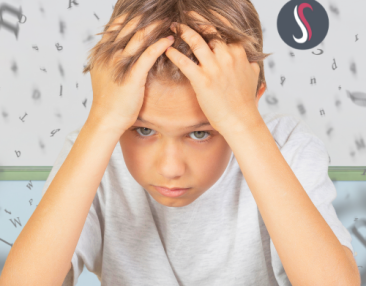 Jeune garçon se tenant la tête qui a des difficultés scolaires