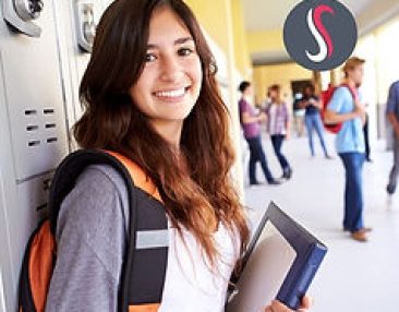 Jeune élève souriante qui est dans la cours tenant des cahiers dans ses mains