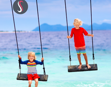 Deux garçons faisant de la balançoire au bord de la mer