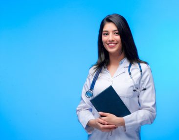 Medical concept of Asian beautiful female doctor in white coat with stethoscope, waist up. Medical student. Woman hospital worker looking at camera and smiling. Covid-19 pandemic.