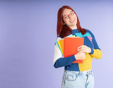 Étudiante qui sourit avec ses cahiers en mains